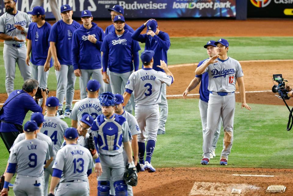 　マーリンズに大勝しタッチを交わす大谷（右端）ら。ドジャースは１２年連続となるプレーオフ進出を決めた＝１９日