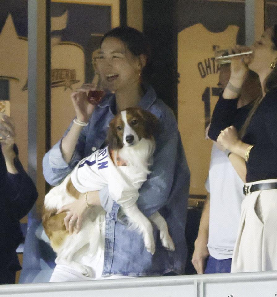 　ドジャースがリーグ優勝を果たし、愛犬を抱いて笑顔を見せる大谷の妻真美子さん＝２０日、ドジャースタジアム（提供・共同通信社）