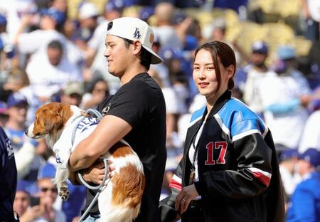 　ドジャースタジアムで行われた優勝報告会を終え、愛犬デコピンを抱いて引き揚げる大谷と妻の真美子さん（共同）