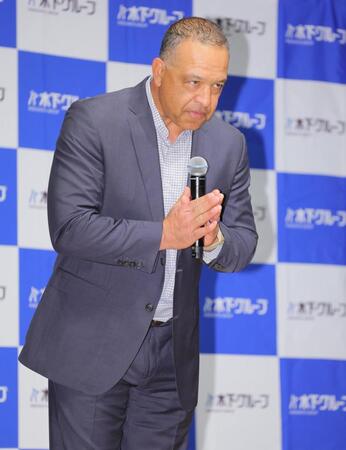 登壇し手を合わせ、あいさつするロバーツ監督（撮影・吉澤敬太）