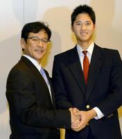 　日本ハム入りを表明し、栗山監督と笑顔で握手する花巻東時代＝１２年１２月