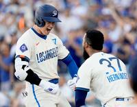 　ブルワーズ戦の８回、２８号ソロを放ち、Ｔ・ヘルナンデス（右）と喜ぶ大谷＝２０２４年７月６日