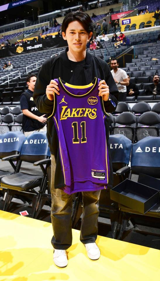 　訪問したレーカーズのユニホームを手にポーズをとるドジャース移籍が決まった佐々木（ＮＢＡＥ・ゲッティ＝共同）