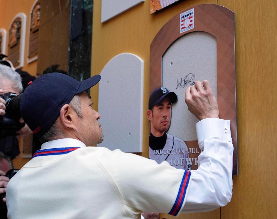 　銅製レリーフの設置予定箇所にサインするイチローさん（共同）