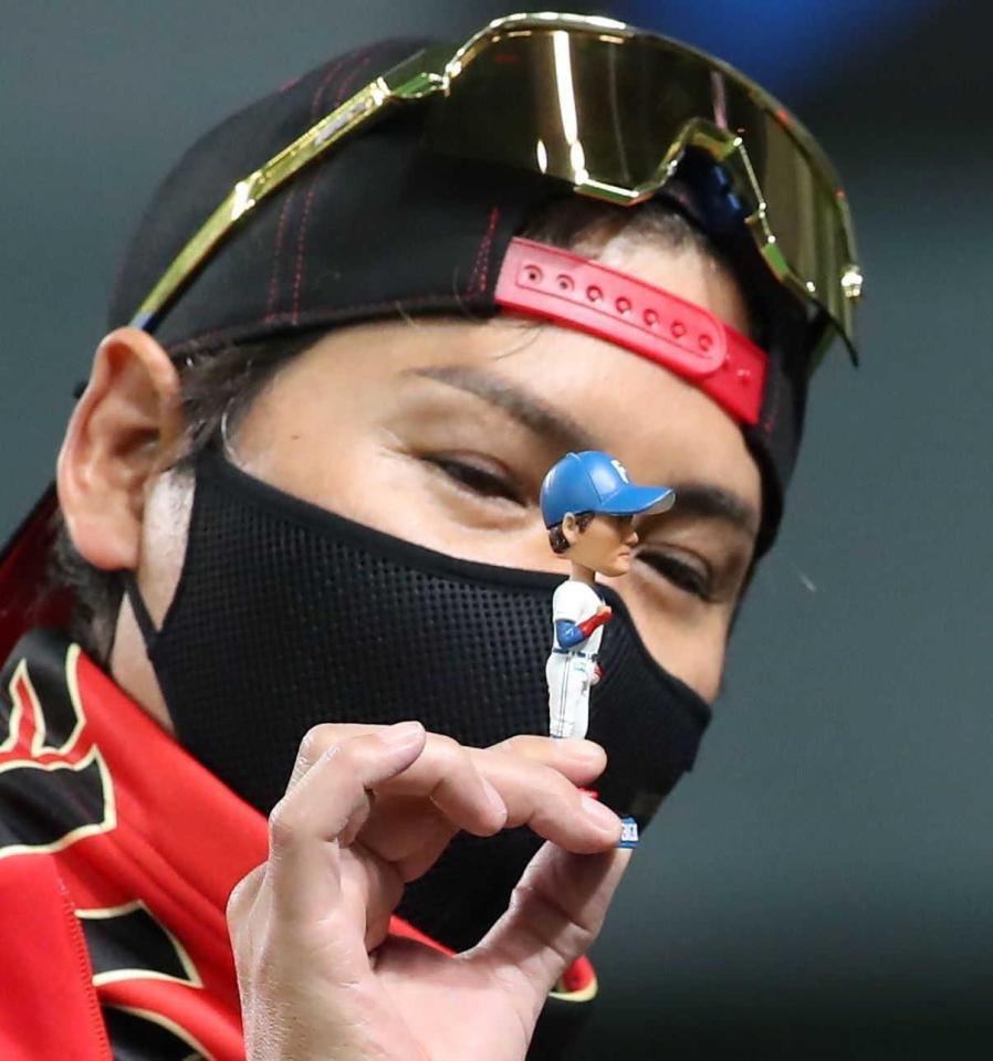 ＢＩＧＢＯＳＳのボブルヘッドをテレビカメラに見せる新庄剛志ビッグボス（左）＝２２年７月