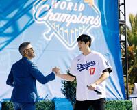 　ファン感謝イベントでステージに登場し、司会者と握手を交わす大谷（共同）