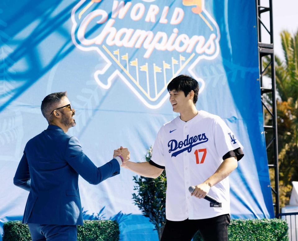 　ファン感謝イベントでステージに登場し、司会者と握手を交わす大谷（共同）