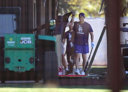 　バットを手に練習場へ向かう大谷（右）＝共同