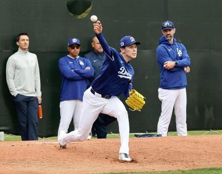 　ブルペンで投球練習する佐々木。左から２人目はロバーツ監督、右端はプライアー投手コーチ