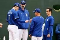 　ブルペンで投球練習後、ロバーツ監督（右から２人目）とタッチを交わす佐々木。奥はプライアー投手コーチ