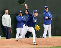 　ブルペンで投球練習する佐々木。左から２人目はロバーツ監督、右端はプライアー投手コーチ