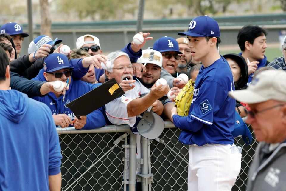 　キャンプ初日、ファンにサインする佐々木朗希（共同）