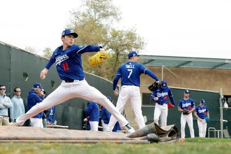 　ブルペンで投球練習するドジャース・佐々木。左から２人目はスネル（共同）