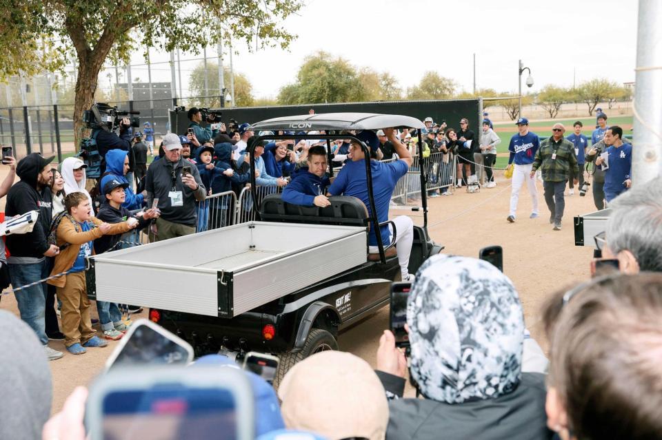 　カートに乗って練習場を移動する大谷（右）。右奥は佐々木（共同）