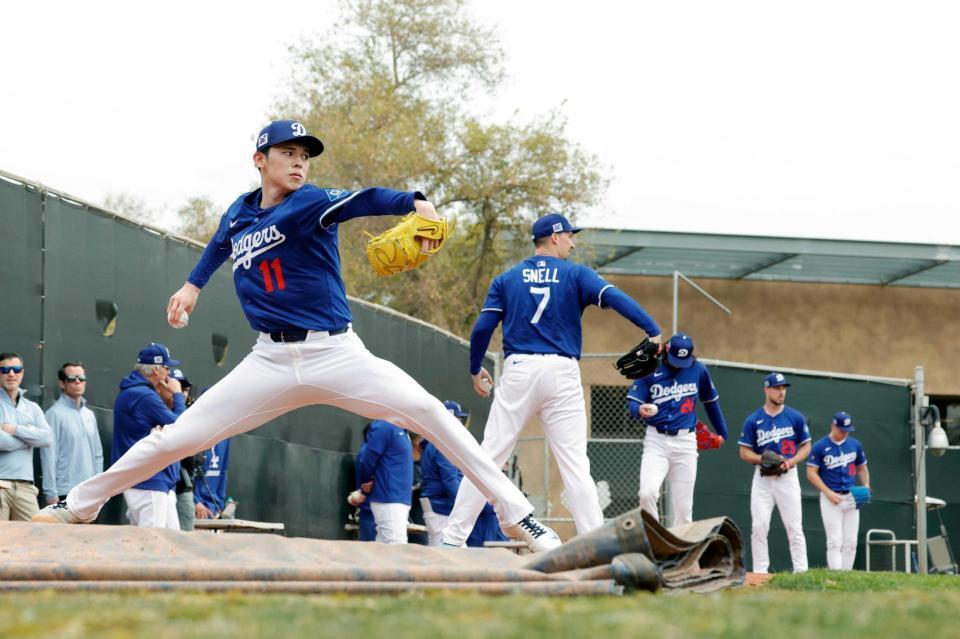 　ブルペンで投球練習するドジャース・佐々木。左から２人目はスネル（共同）