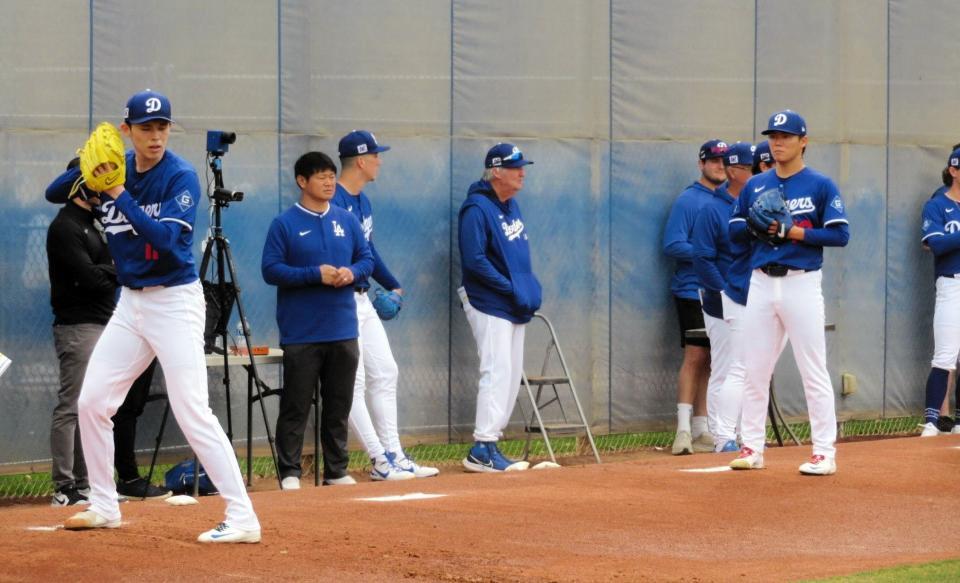 　ブルペンで並んで投球練習を行う佐々木と山本（撮影・小林信行）