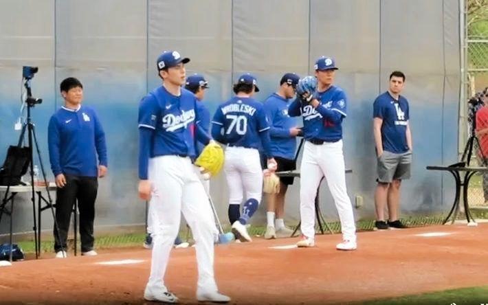 　ブルペンで並んで投球練習を行う佐々木と山本。佐々木が投げ終えて山本がモーションに（撮影・小林信行）