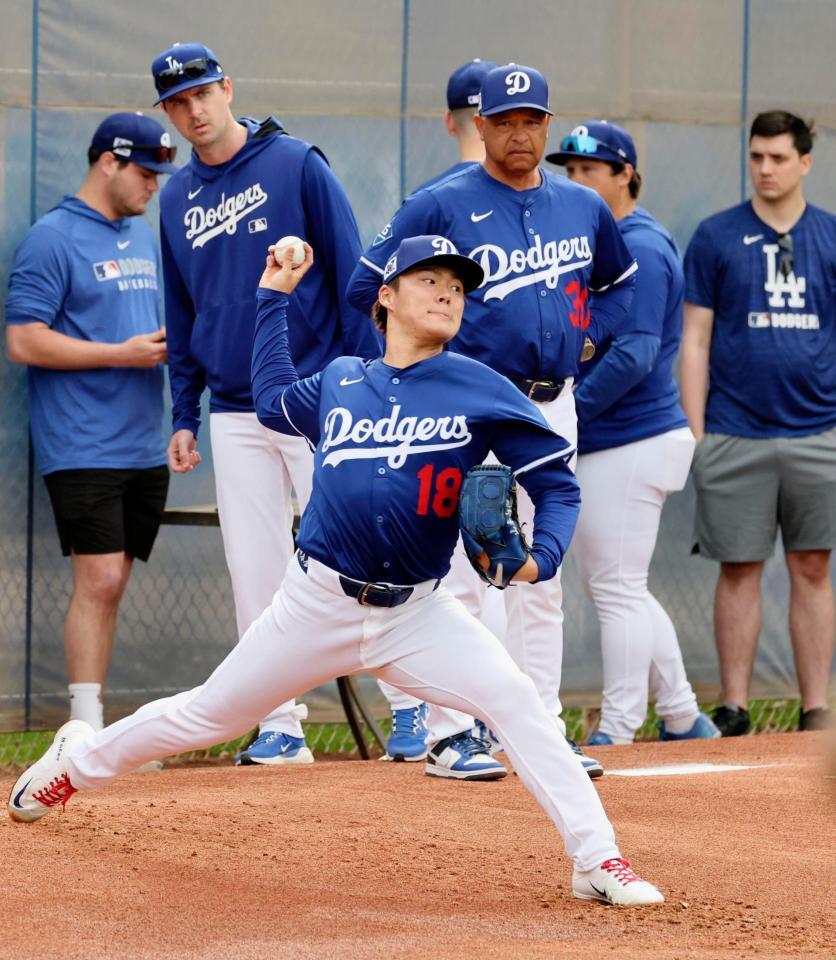 　ロバーツ監督（奥中央）が見守る中、投球練習するドジャース・山本＝グレンデール（共同）