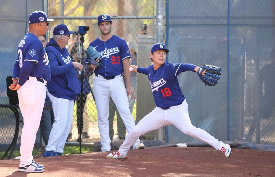 　ブルペンで投球する山本。左端はロバーツ監督（共同）