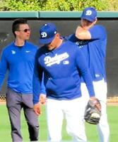 　キャッチボールを終え、引き揚げる際に背中を押さえる大谷（撮影・小林信行）