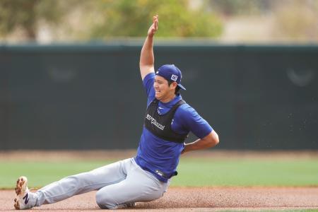 　走塁練習のスライディングで左手を腰に添えながら滑り込むドジャース・大谷＝グレンデール（共同）