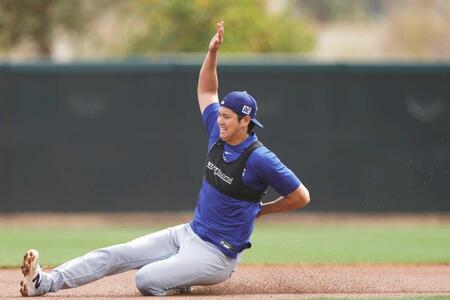 　走塁練習のスライディングで左手を腰に添えながら滑り込むドジャース・大谷（共同）