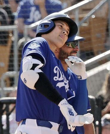 　レンジャーズ戦の６回、左前打を放ち、コーチと頭をぶつけ合う大谷（共同）