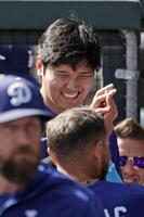 　試合中、ベンチで笑顔を見せる大谷（奥）＝共同