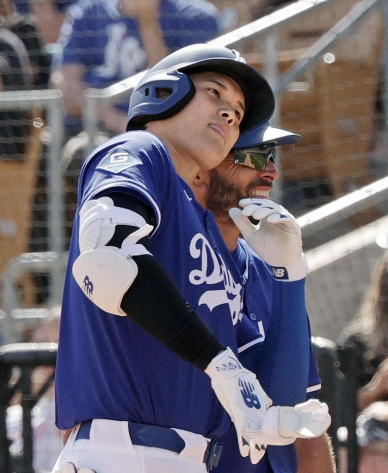 　レンジャーズ戦の６回、左前打を放ち、コーチと頭をぶつけ合う大谷（共同）