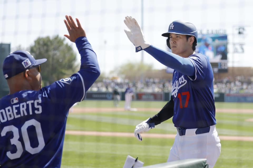 　ダイヤモンドバックス戦の１回、フリーマンの２点二塁打で生還し、ロバーツ監督（左）に迎えられるドジャース・大谷（共同）