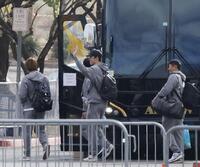 　キャンプ施設から、米大リーグの開幕シリーズが行われる東京に向け出発する佐々木（中央）＝共同