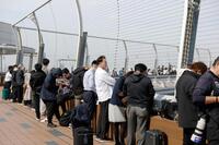 　米大リーグ開幕戦を前に、羽田空港に集まった人たち＝13日午後