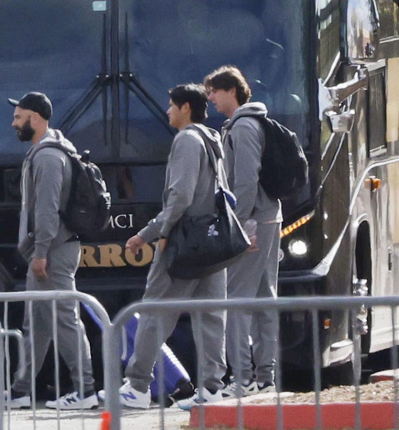 　キャンプ施設から、米大リーグの開幕シリーズが行われる東京に向け出発する大谷（中央）＝共同