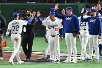 　巨人に勝利し、ナインとタッチを交わすロバーツ監督（中央）