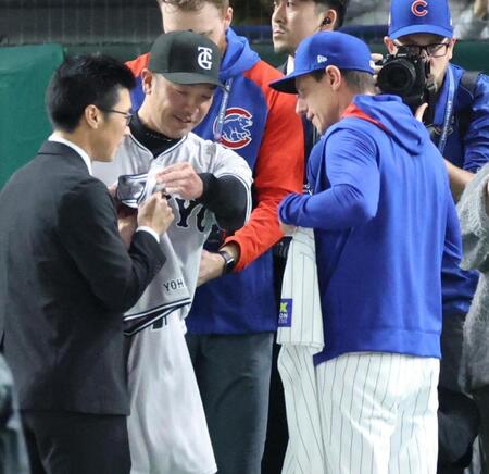 　試合前、ユニホームを交換する阿部監督（左から２人目）とカウンセル監督（撮影・吉澤敬太）