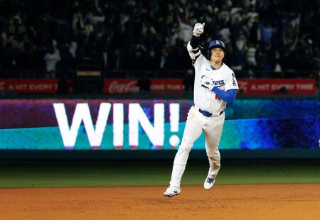 　外野フェンスに浮かぶ「ＷＩＮ！」の文字を背に塁を回る大谷（共同）