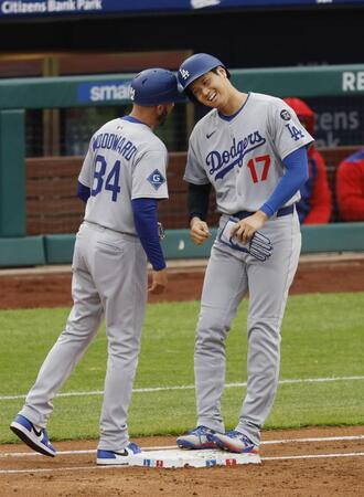 　３回、四球で出塁し、一塁コーチとヘルメットを合わせる大谷（共同）