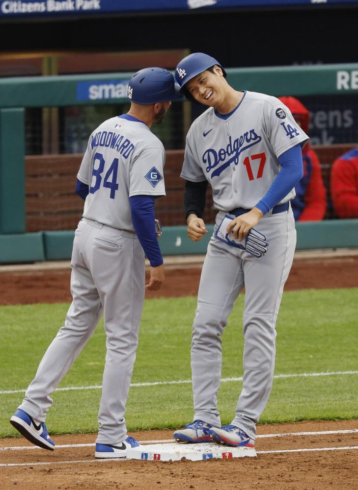 　３回、四球で出塁し、一塁コーチとヘルメットを合わせる大谷（共同）