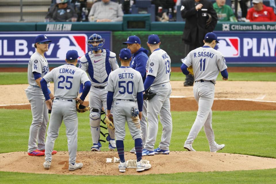 　５回途中、ロバーツ監督（右から３人目）に交代を告げられマウンドを降りる佐々木（１１）＝共同