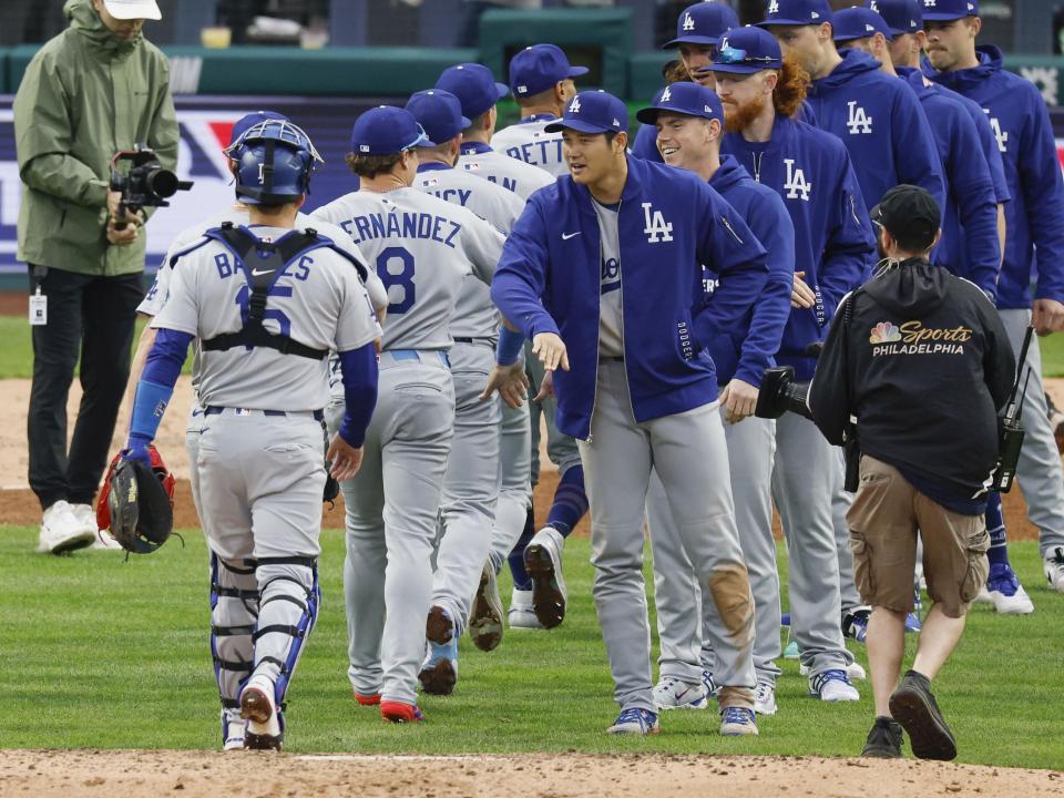 　勝利し、チームメートとタッチを交わす大谷（手前右）＝共同