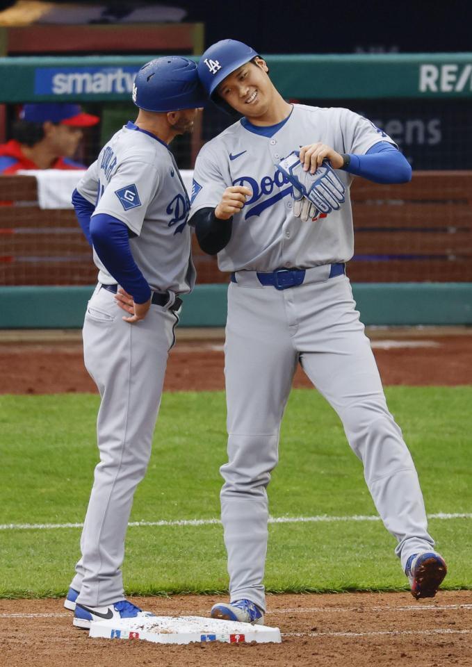 　７回、四球で出塁し、一塁コーチとヘルメットを合わせる大谷（共同）