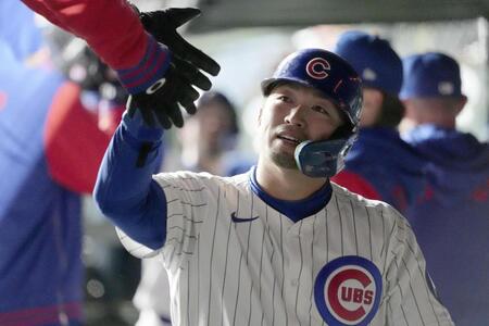 　５回、後続の犠飛で生還し、ベンチでタッチを交わす鈴木（共同）