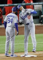 　９回、右前打で出塁し、一塁コーチとヘルメットを合わせる大谷（共同）