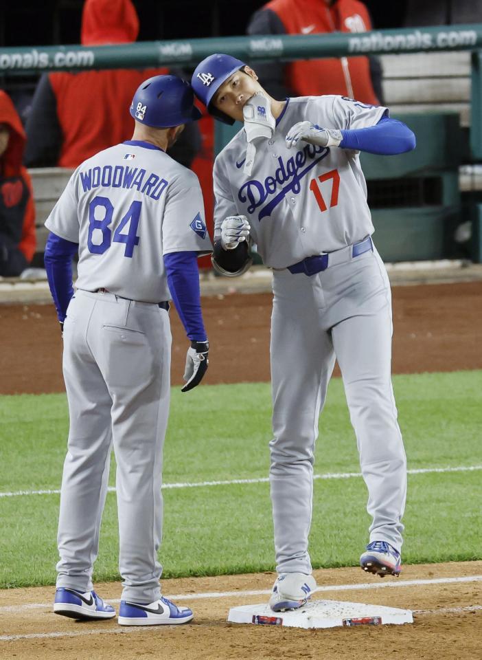 　９回、右前打で出塁し、一塁コーチとヘルメットを合わせる大谷（共同）