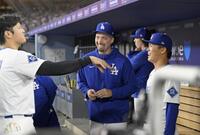 　６回、ベンチで笑顔を見せる山本（右）。左は大谷（共同）