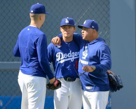 　ブルペンでの投球練習を終え、ロバーツ監督（右）らと話すドジャース・山本（中央）＝ロサンゼルス（共同）