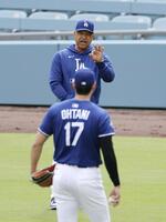 　キャッチボール中の大谷（手前）と話をするロバーツ監督（共同）
