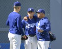 　ブルペンでの投球練習を終え、ロバーツ監督（右）らと話す山本（中央）＝共同