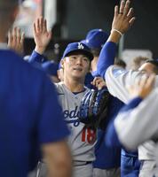 　レンジャーズ戦の７回まで無失点で終え、ハイタッチで迎えられるドジャース先発の山本。３勝目を挙げた（共同）