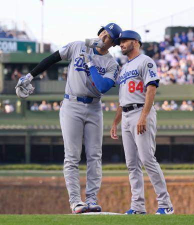 　カブス戦の３回、右前打を放ち、一塁コーチ（右）とヘルメットを合わせるドジャース・大谷＝シカゴ（共同）